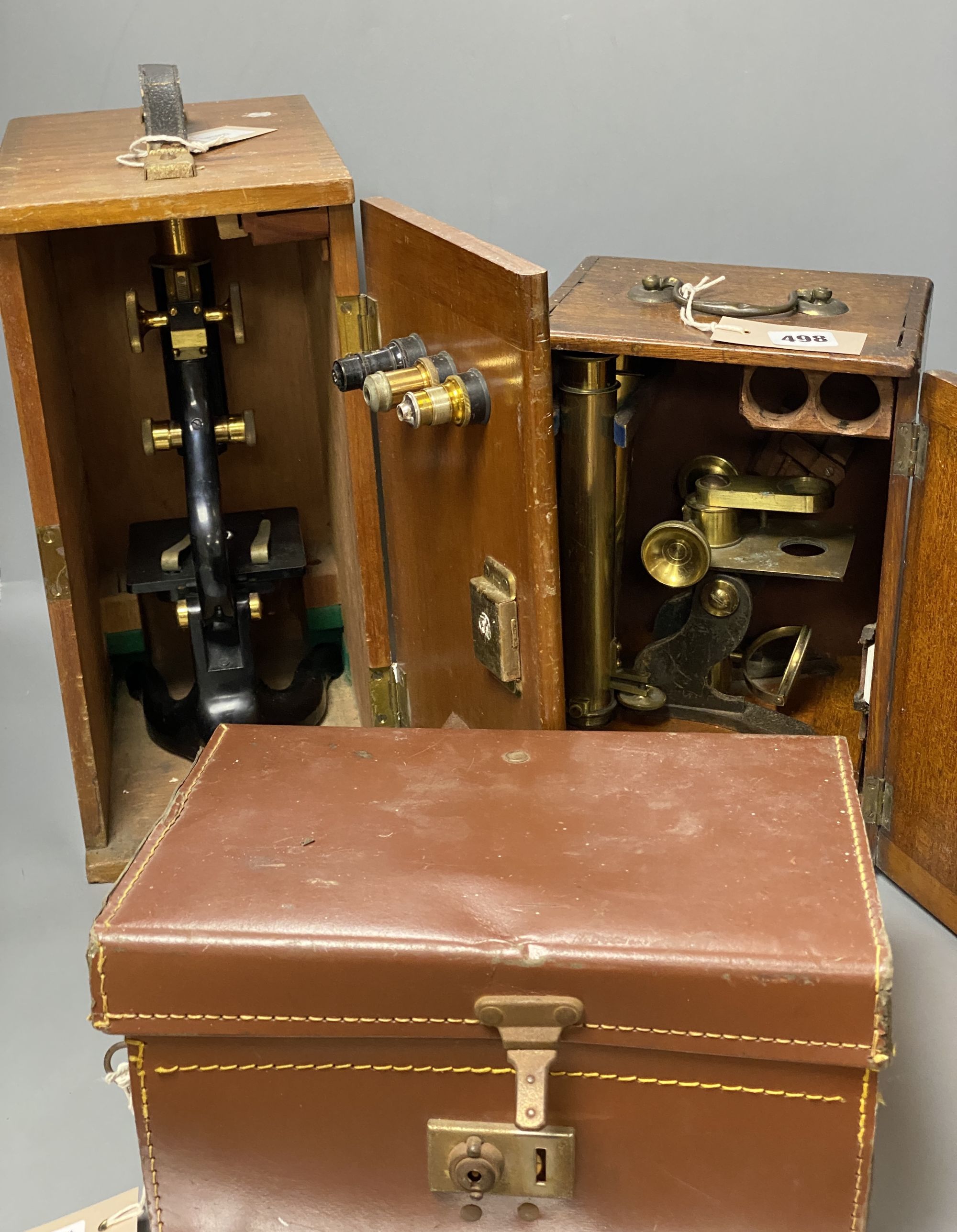 An early 20th century lacquered brass binocular microsope (unnamed) and two other microscopes by Watson & Sons, H 33cm approx